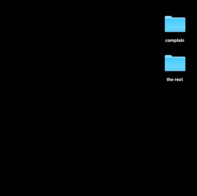 Screenshot of a black computer desktop with two blue file folders named 'complain' and 'the rest'