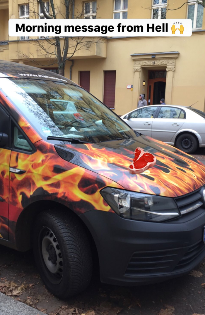A flame-themed car with a meat emojy placed in the front and a text in bold font saying: morning message from hell