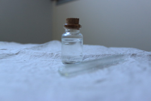 A tiny glass jar sealed with cork and containing rainwater. 